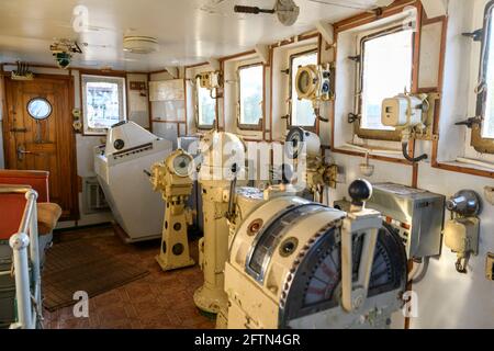 Navigational bridge on abandoned vessel. Old derelict ship wheelhouse. Ship's control device. Russian words: Ahead/Astern, full, half, slow, dead slow Stock Photo