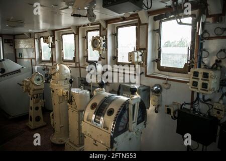 Navigational bridge on abandoned vessel. Old derelict ship wheelhouse. Ship's control device. Russian words: Ahead/Astern, full, half, slow, dead slow Stock Photo