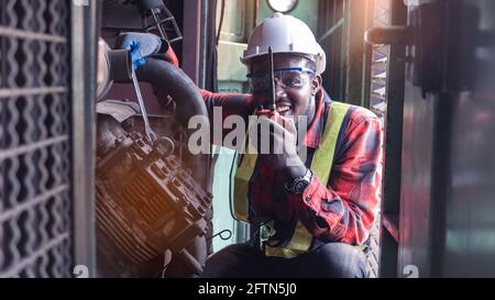 African engineering engine machine controller checking, working with walk radio communication or walkie-talkie in room system in industry Stock Photo