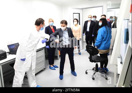 Beijing, China. 21st May, 2021. Serbian Prime Minister Ana Brnabic touches elbows with a Serbian expert to greet each other at the opening of the Laboratory for Molecular Detection of Infectious Agents dubbed 'Fire Eye' in Belgrade, Serbia, on April 20, 2020. TO GO WITH XINHUA HEADLINES OF MAY 21, 2021 Credit: Xinhua/Alamy Live News Stock Photo