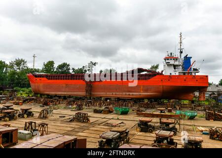 Cargo vessel ashore on ship repairing yard. Summer time. Stock Photo