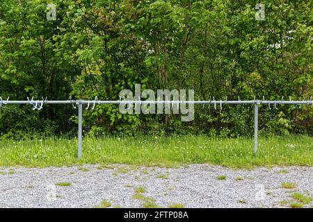 Empty bike racks for bikes on a gravel path in front of green forest, during the day, without people, in nature you can still find free parking spaces Stock Photo