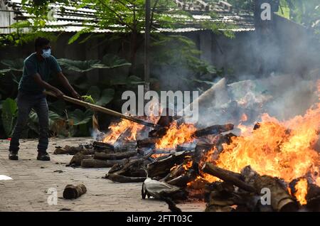 Guwahati, India. May 21, 2021: Municipality workers performing last rites of a person, who died from COVID-10 coronavirus disease, at a crematorium in Guwahati. Credit: David Talukdar/ZUMA Wire/Alamy Live News Stock Photo