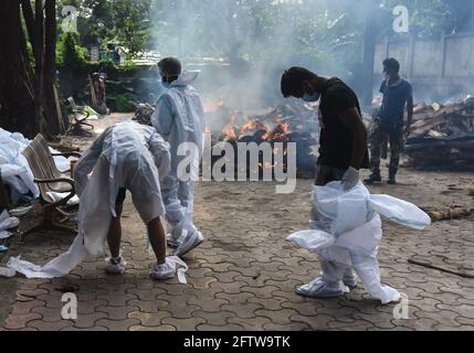 May 21, 2021: Guwahati, India: Municipality workers remove PPE kit after carry a dead body, who died from COVID-10 coronavirus disease, at a crematorium in Guwahati. Credit: David Talukdar/ZUMA Wire/Alamy Live News Stock Photo