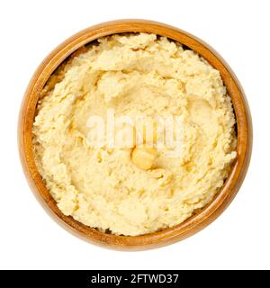 Hummus dip with chickpea garnish, in a wooden bowl. Middle Eastern dip, spread or savory dish made of cooked, mashed chickpeas, blended with tahini. Stock Photo