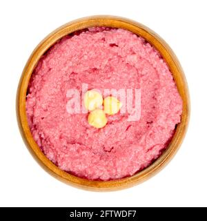 Beetroot hummus dip with chickpea garnish in a wooden bowl. Middle Eastern dip, spread or savory dish made of cooked, mashed chickpeas. Stock Photo