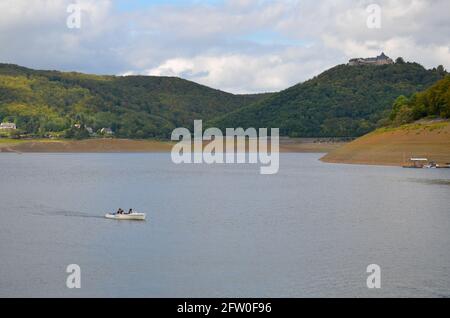 Edersee, Hessen, Germany - September 10 2011: View of the Edersee with the Waldeck fortress and mountains in the background and a small boat Stock Photo