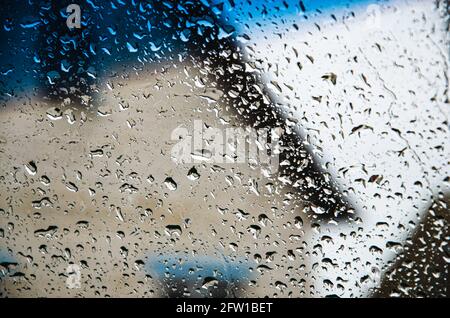 Rain drops on window glasses surface with cloudy background Stock Photo