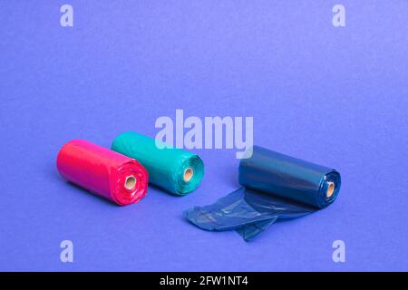 Multicolored rolls of plastic bags on blue background close up Stock Photo