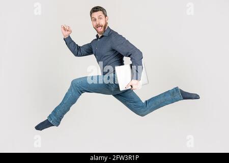 energetic man businessman running while working online on laptop hurry up for shopping, motion. Stock Photo
