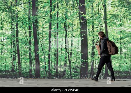 A man walks past a mural of a forest in downtown Washington, DC. Stock Photo