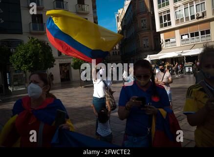 Malaga, Spain. 22nd May, 2021. A Colombian protester wearing a face mask waves a Colombian flag during the demonstration at Plaza de la Constitucion square.Colombian residents in Malaga take to the streets again in solidarity with the Colombians and against the government of President Iván Duque as negotiations continue between the Colombian government and the committee of the national strike after which protests and violent clashes erupted in the country. Credit: SOPA Images Limited/Alamy Live News Stock Photo