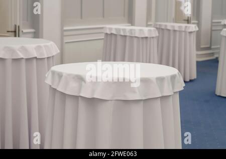 Buffet tables covered with white tablecloths in a beautiful interior. Stock Photo