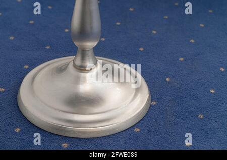 A fragment of a stylish silver coffee table on a blue carpet. Stock Photo
