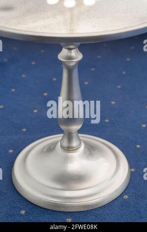 A fragment of a stylish silver coffee table on a blue carpet. Stock Photo