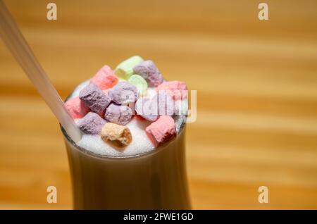 Pink, lilac, multi-colored mini marshmallows in ceramic dishes. View of cocktail decorated with colorful marshmallows on wooden background with place Stock Photo