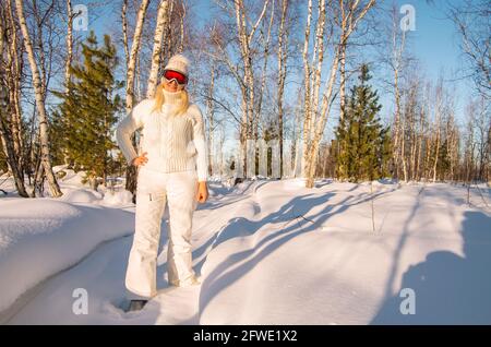 Happy young woman enjoying winter vacation in snowy forest. Stock Photo