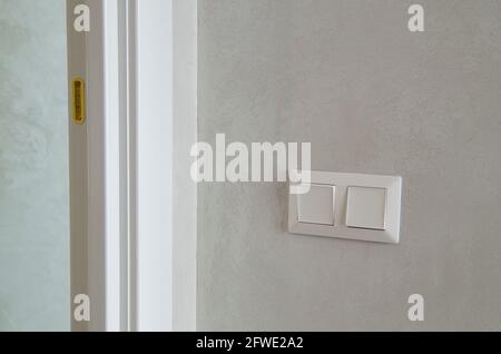 Modern light switch on the wall in the room. Stock Photo