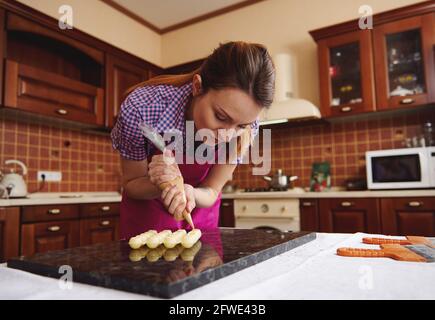 Closeup of squeezing filling of salted caramel cream from confectionery bag  into candy molds for preparing handmade chocolate pralines Stock Photo -  Alamy