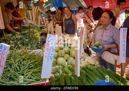 Shopper buying groceries at a fresh produce stall in Yau Ma Tei, Hong Kong. Stock Photo