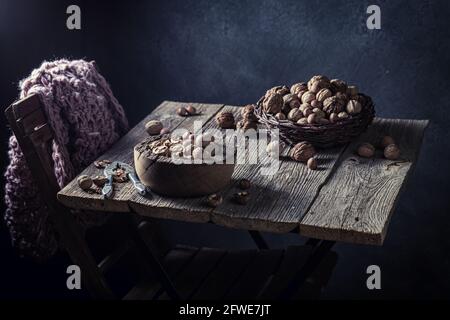 Various nuts and nutcracker. Walnuts and hazelnuts on the old table. Rustic table with walnuts and hazelnuts. Stock Photo