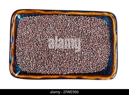 top view of black mustard (Brassica nigra) seeds in ceramic bowl cutout on white background