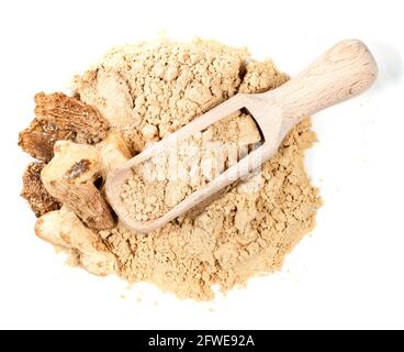 top view of wood scoop on pile of dried ginger roots and powder on white background Stock Photo