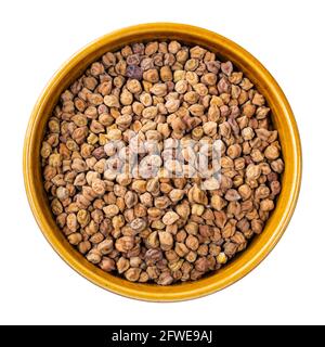 top view of raw black chickpeas in round bowl cutout on white background Stock Photo