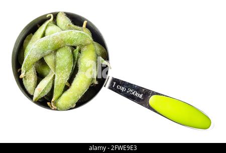 top view of frozen Edamame unripe soybeans in pod in measuring cup cutout on white background Stock Photo