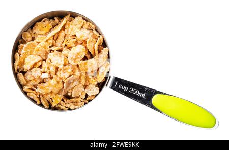 top view of sugar-coated cornflakes in measuring cup cutout on white background Stock Photo