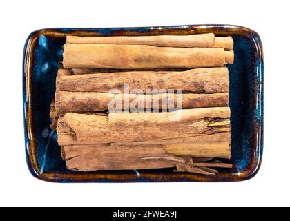 top view of sticks of continental ceylon cinnamon in ceramic bowl cutout on white background Stock Photo