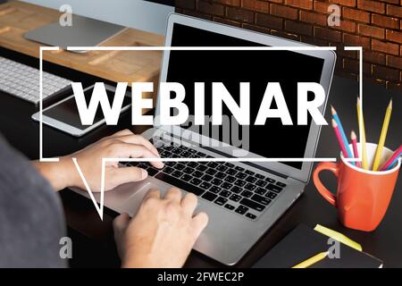 WEBINAR hand on table use E-business Browsing Connection in computer  Webinar with person on laptop display conference, webinar Stock Photo