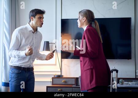 young business couple arguing in hotel room. Stock Photo