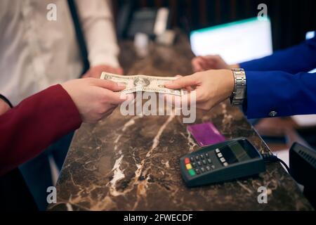 paying in cash at hotel reception. detail, hands, from hand to hand Stock Photo