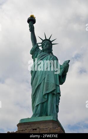 New York, New York, USA - July 23 2013: The Statue of Liberty on Liberty Island under cloudy sunny skies Stock Photo