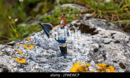 Toy soldier with flag on a rock Stock Photo