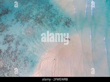Aerial shot of the Mnemba Island white sand sandbanks washed with turquoise Indian ocean waves near the Zanzibar island, Tanzania. The couple came her Stock Photo
