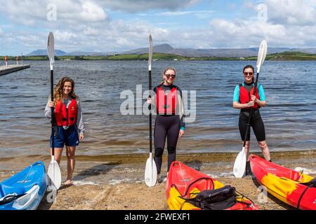 Bantry, West Cork, Ireland. 22nd May, 2021. The sun shone on Bantry this morning with many locals and visitors taking full advantage of the good weather. Bantry Bay Boat Hire was doing a brisk trade - pictured preparing to go kayaking are Aileen Daly, Bantry; Aoibhlinn Delany, Cork and Marie Ruane, Cork. Credit: AG News/Alamy Live News Stock Photo