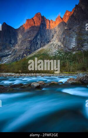 Early morning light with alpenglow on the mountains, and streaming water in Rauma river in Romsdalen valley, Rauma kommune, Møre og Romsdal, Norway. Stock Photo