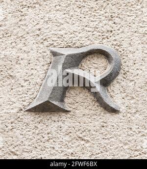 Capital letter R on roughly plastered wall Stock Photo