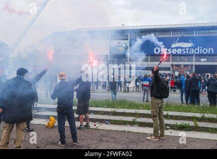 Rostock, Germany. 22nd May, 2021. Football: 3. league, Hansa Rostock - VfB Lübeck, 38th matchday: Fanbs of FC Hansa Rostock celebrate after the match against VfB Lübeck in front of the Ostseestadion the promotion to the second league and burn pyrotechnics. Credit: Jens Büttner/dpa-Zentralbild/dpa/Alamy Live News Stock Photo