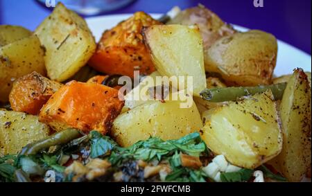 Close up shot of baked potatoes and some vegetables Stock Photo