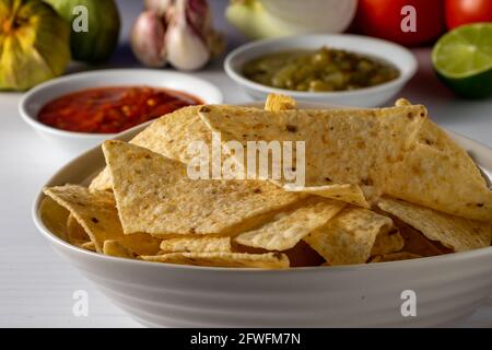 Corn tortilla chips and salsa with raw ingredients. Stock Photo