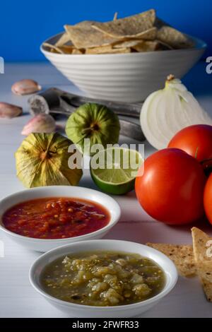 Corn tortilla chips and salsa with raw ingredients. Stock Photo