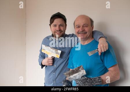 Mature handymen with putty knife smiling looking at camera Stock Photo
