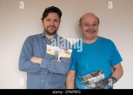 Mature handymen with putty knife smiling looking at camera Stock Photo