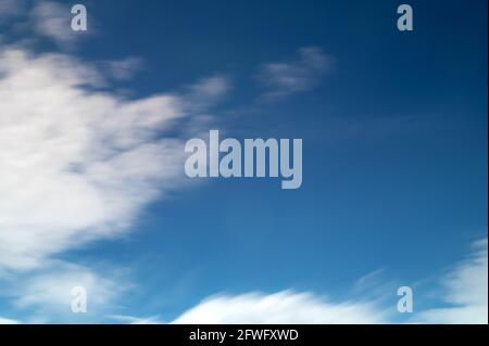 Blurred clouds on blue sky. Blue sky background with cumulus clouds. Blurred motion Stock Photo