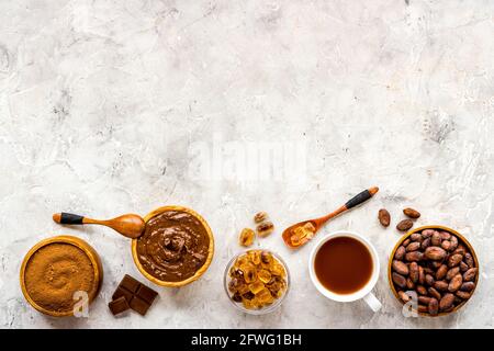 Cocoa beans and powder with hot chocolate in white cup. Top view, flat lay Stock Photo