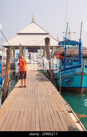 Koh Chang, Thailand-01.18.2020: Tourists on the sea pier with pleasure boats in Asia. Stock Photo