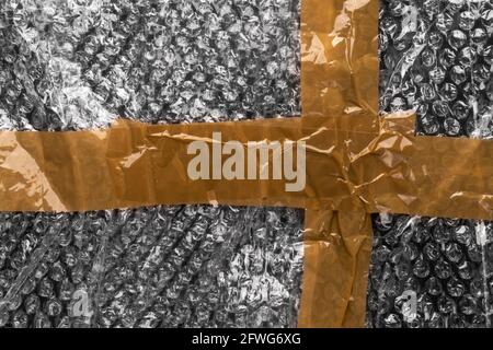 Adhesive tape on a bubble wrap. Wrinkled abstract plastic surface. Delivery concept Stock Photo